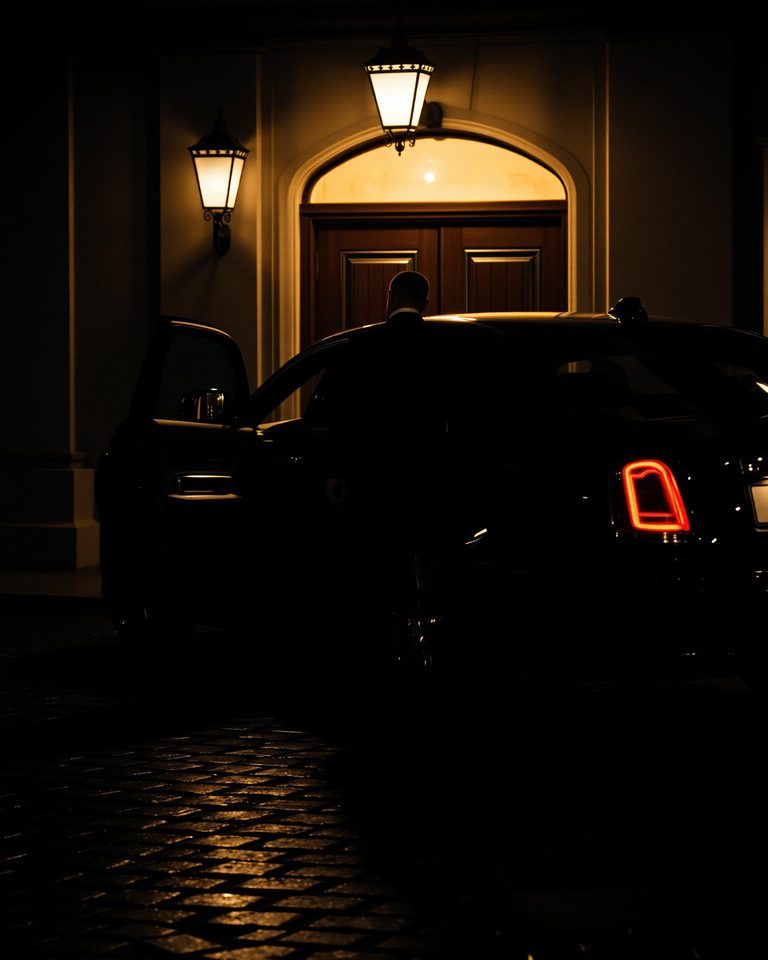A chauffeur waiting beside the car